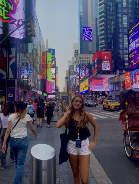 Nora Atienza happily posing in Times Square in New York City